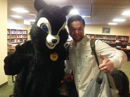 Student posing with University Libraries mascot, Rocky at 2014 Welcome Week event.